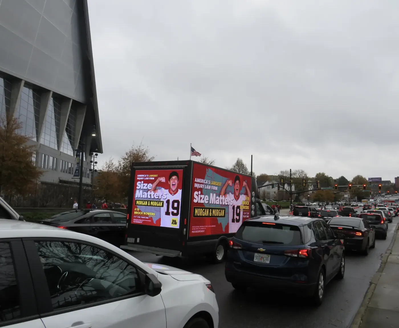 A Morgan & Morgan digital billboard truck in pregame traffic beside Mercedes-Benz Stadium in Atlanta